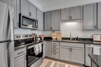 a kitchen with stainless steel appliances and gray cabinets
